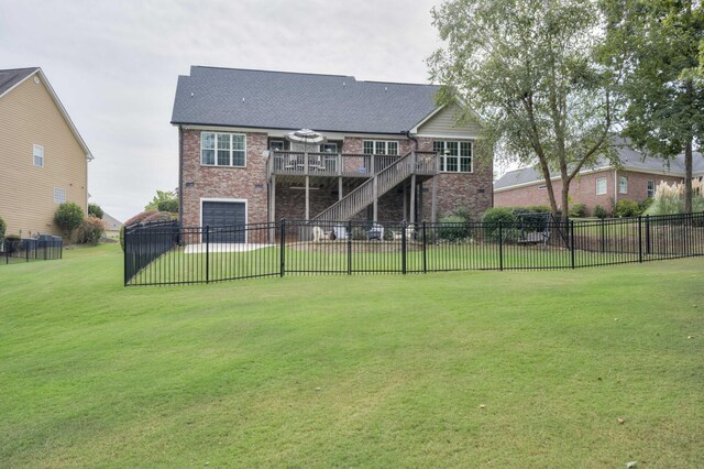 rear view of house featuring a lawn and a deck