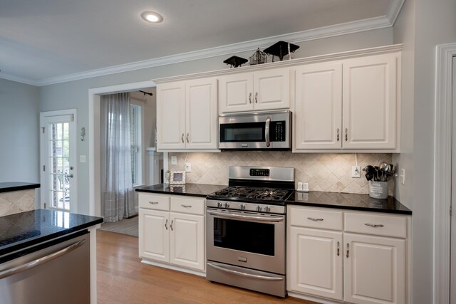 kitchen featuring white cabinets, stainless steel appliances, light hardwood / wood-style flooring, and crown molding