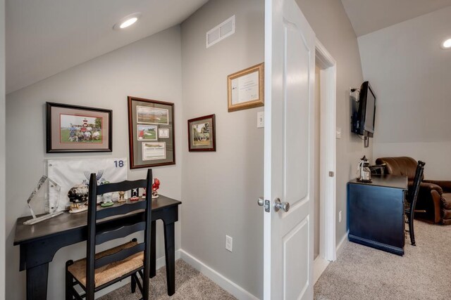 carpeted home office featuring lofted ceiling