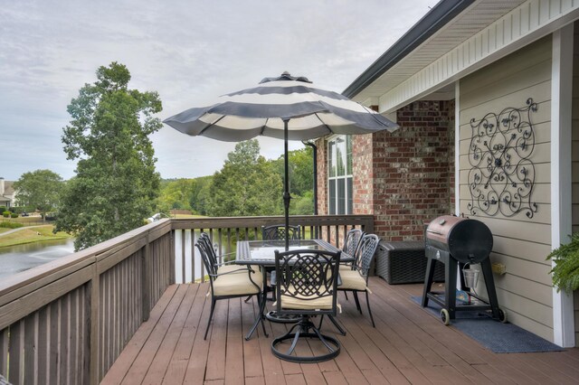 wooden terrace featuring a water view and grilling area