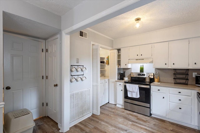 2920 Arrowhead Dr, Augusta, GA 30909 - kitchen with electric range, independent washer and dryer, under cabinet range hood, a textured ceiling, and white cabinets