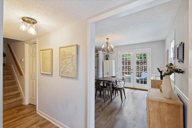 2920 Arrowhead Dr, Augusta, GA 30909 - corridor featuring stairway, wood finished floors, a textured ceiling, a chandelier, and baseboards
