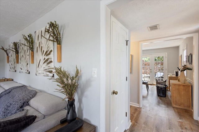 2920 Arrowhead Dr, Augusta, GA 30909 - hallway with a textured ceiling, light wood-style flooring, french doors, and baseboards