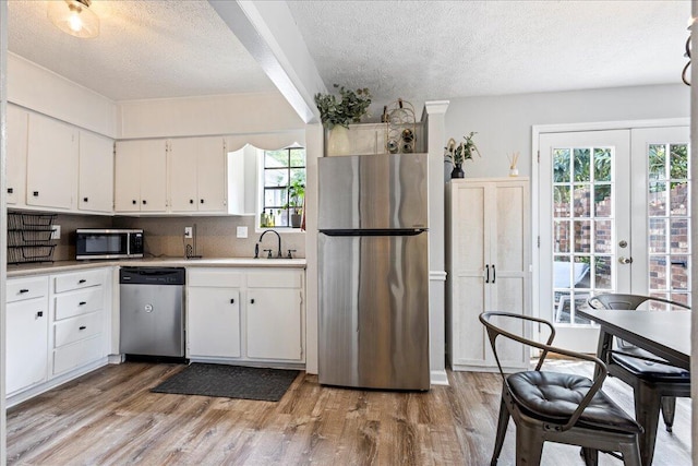 2920 Arrowhead Dr, Augusta, GA 30909 - kitchen featuring appliances with stainless steel finishes, a textured ceiling, light wood-type flooring, and plenty of natural light