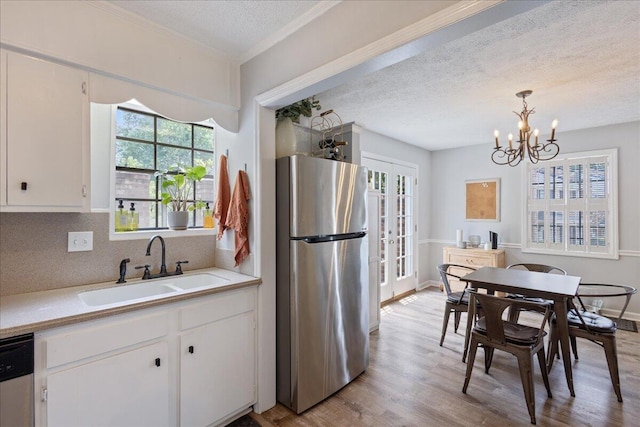 2920 Arrowhead Dr, Augusta, GA 30909 - kitchen featuring freestanding refrigerator, a sink, a textured ceiling, dishwashing machine, and light countertops