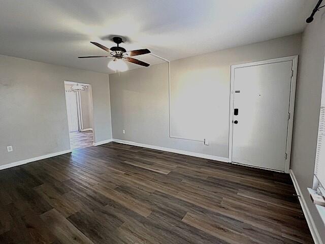 spare room with ceiling fan and dark wood-type flooring