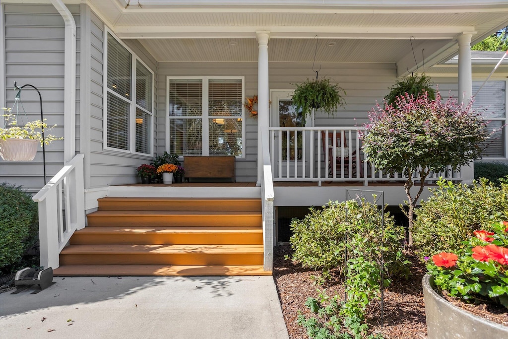 view of exterior entry featuring covered porch