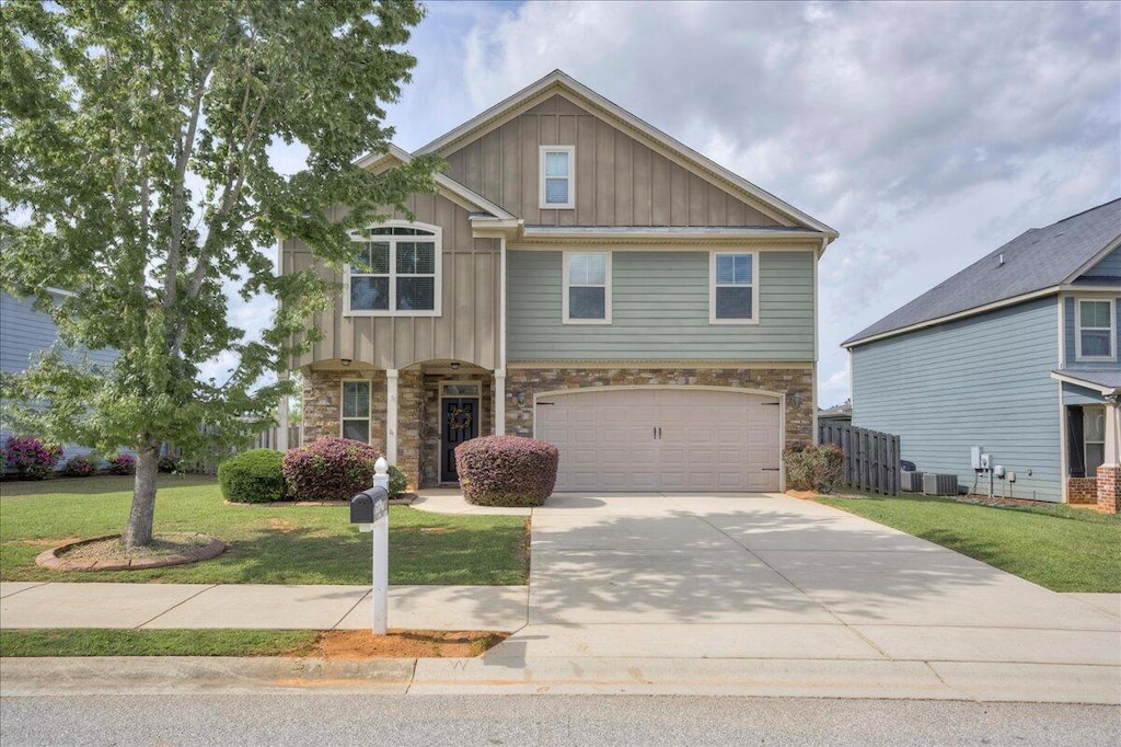 craftsman inspired home featuring stone siding, driveway, a front lawn, and board and batten siding
