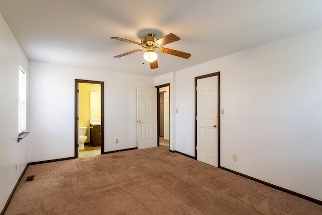 unfurnished bedroom with visible vents, baseboards, ensuite bath, a textured ceiling, and light colored carpet