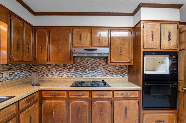 4558 Glenda Ln, Evans, GA 30809 - kitchen with black appliances, under cabinet range hood, light countertops, crown molding, and decorative backsplash