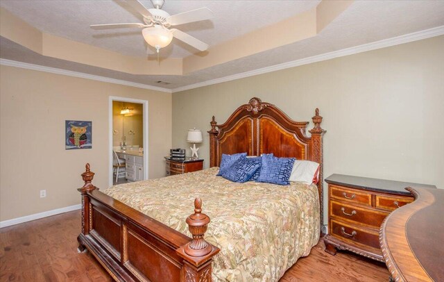 900 Mitchell Ln, Evans, GA 30809 - bedroom featuring a tray ceiling, light wood-style flooring, baseboards, ornamental molding, and ensuite bath
