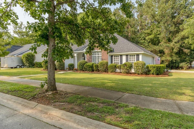 900 Mitchell Ln, Evans, GA 30809 - view of property hidden behind natural elements featuring a front lawn, a shingled roof, and brick siding