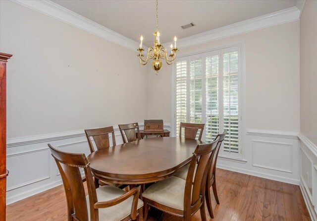 900 Mitchell Ln, Evans, GA 30809 - dining room featuring a chandelier, crown molding, light wood-type flooring, a decorative wall, and a wainscoted wall