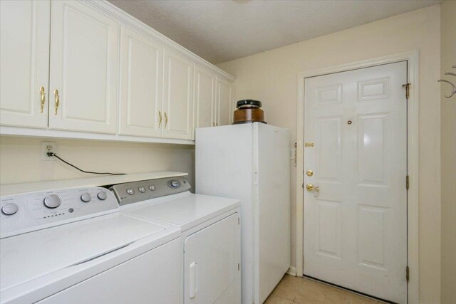 900 Mitchell Ln, Evans, GA 30809 - laundry area with washing machine and clothes dryer, cabinet space, and light tile patterned flooring