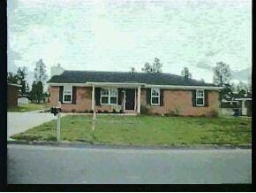 single story home featuring a front lawn