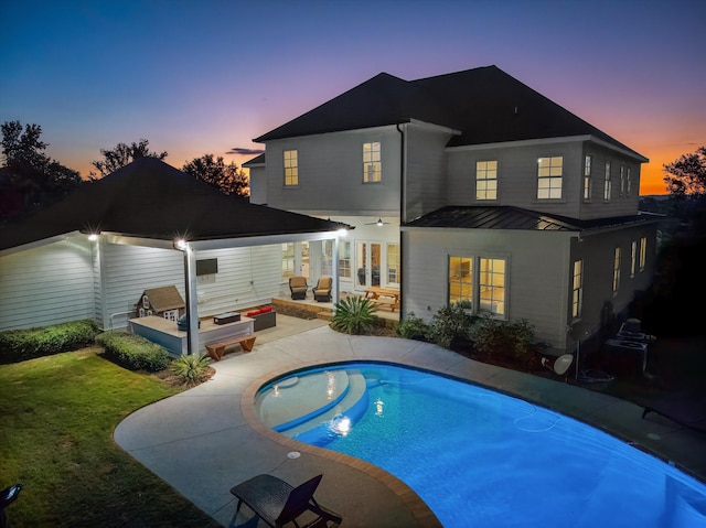 5099 Grande Park, Evans, GA 30809 - back of house at dusk featuring a standing seam roof, a patio, a lawn, metal roof, and an outdoor pool