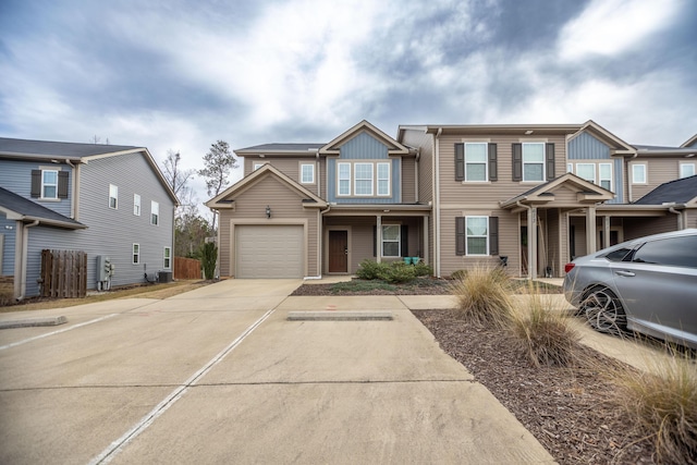 multi unit property featuring driveway, an attached garage, and fence