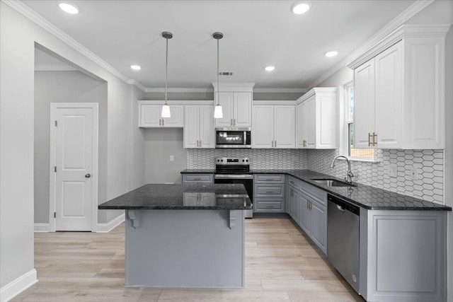 5051 Anna Way Unit Fb23, North Augusta, SC 29841 - kitchen featuring stainless steel appliances, white cabinetry, a kitchen island, dark stone counters, and light wood-style floors