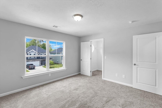 5051 Anna Way Unit Fb23, North Augusta, SC 29841 - unfurnished bedroom featuring carpet, a spacious closet, and a textured ceiling