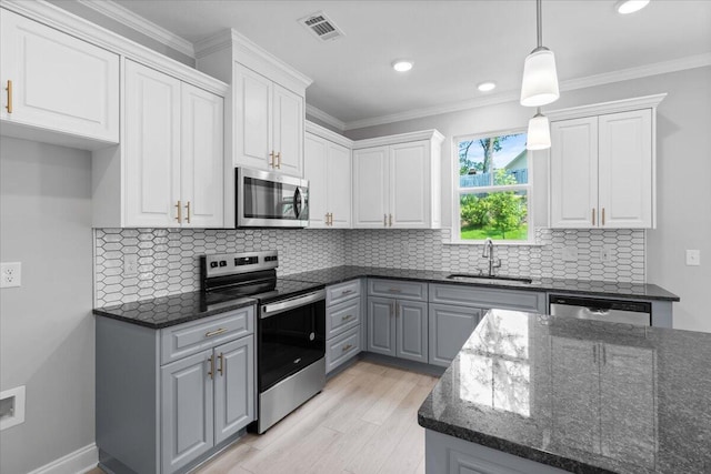 5051 Anna Way Unit Fb23, North Augusta, SC 29841 - kitchen with appliances with stainless steel finishes, white cabinetry, dark stone countertops, pendant lighting, and decorative backsplash