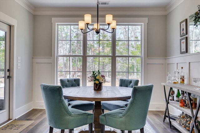 338 Pro Cir, Mccormick, SC 29835 - dining area featuring visible vents, a decorative wall, dark wood finished floors, ornamental molding, and a notable chandelier