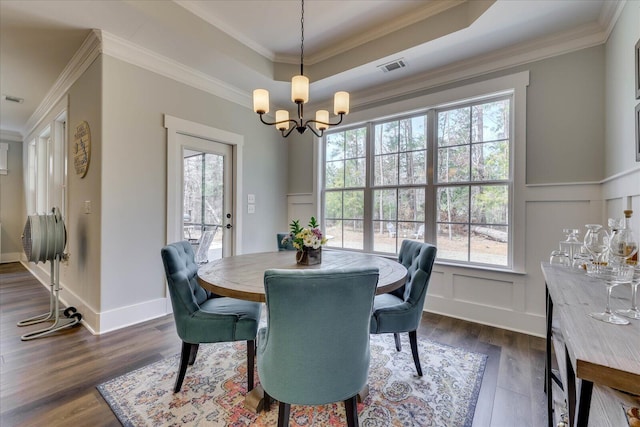 338 Pro Cir, Mccormick, SC 29835 - dining space featuring visible vents, a decorative wall, dark wood-type flooring, ornamental molding, and a notable chandelier