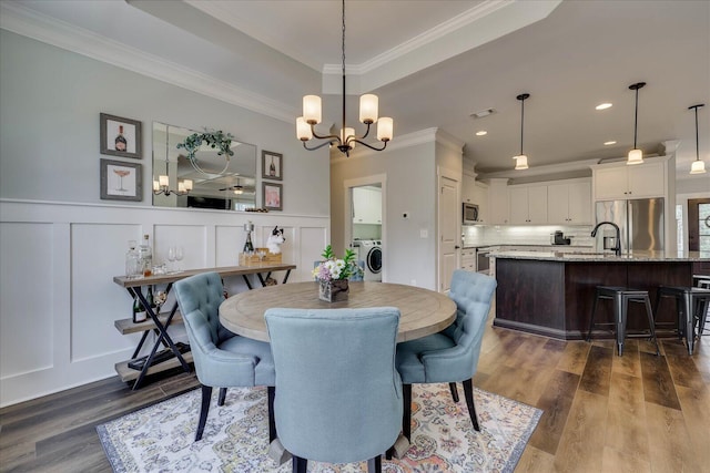 338 Pro Cir, Mccormick, SC 29835 - dining room with a notable chandelier, ornamental molding, a decorative wall, and dark wood-style flooring