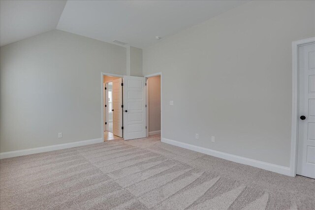 carpeted spare room featuring lofted ceiling