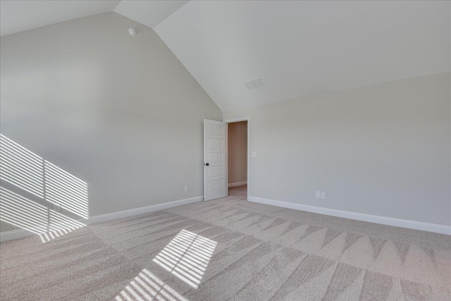 unfurnished room with lofted ceiling and light carpet