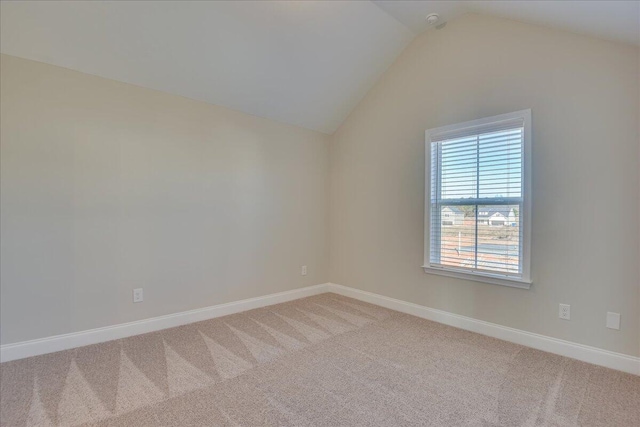 unfurnished room with lofted ceiling and carpet floors