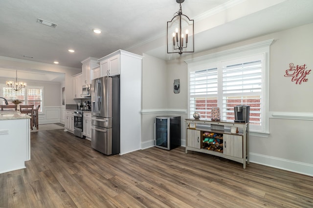 kitchen featuring pendant lighting, white cabinetry, a chandelier, stainless steel appliances, and dark wood-type flooring