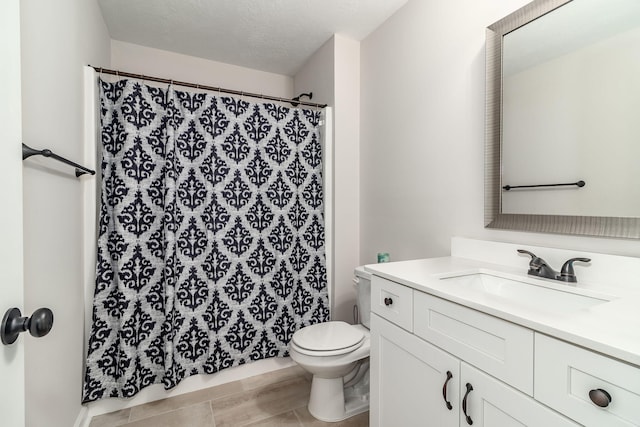 bathroom with vanity, a textured ceiling, and toilet