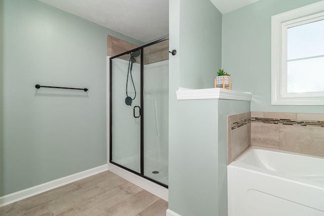 bathroom featuring hardwood / wood-style flooring and plus walk in shower