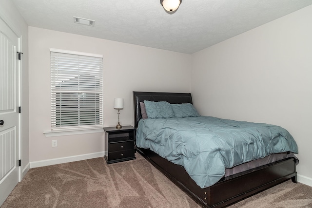 carpeted bedroom featuring a textured ceiling