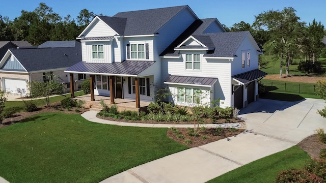 modern farmhouse style home featuring covered porch, a garage, and a front yard