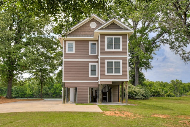 back of property featuring a lawn and concrete driveway