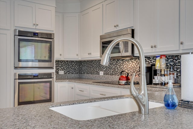 kitchen featuring white cabinetry, appliances with stainless steel finishes, and tasteful backsplash