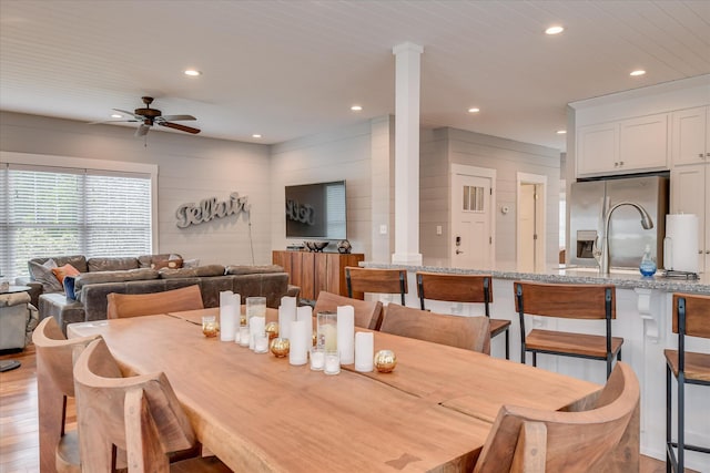 dining space featuring recessed lighting, decorative columns, ceiling fan, and light wood-type flooring