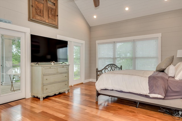 bedroom featuring wood walls, light wood-type flooring, high vaulted ceiling, access to outside, and recessed lighting