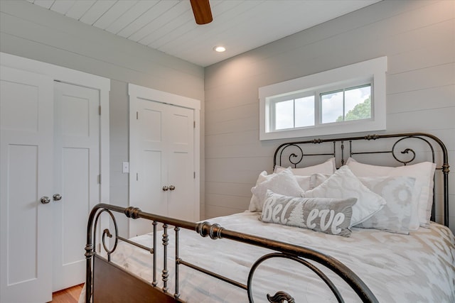 bedroom featuring wooden walls, ceiling fan, recessed lighting, and light wood-style flooring