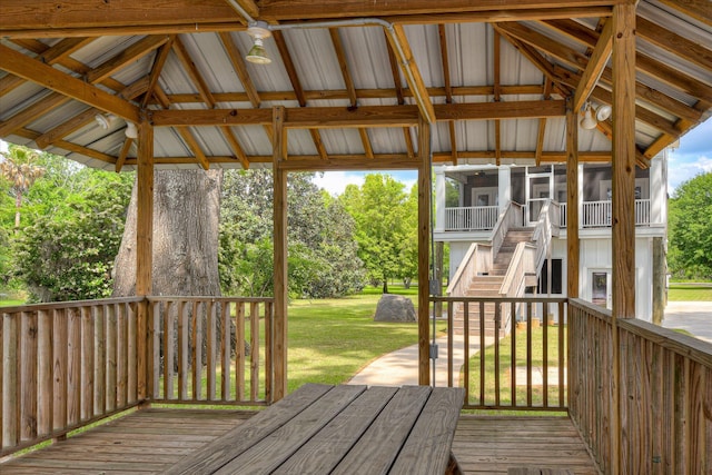 deck with a lawn, stairs, and a sunroom