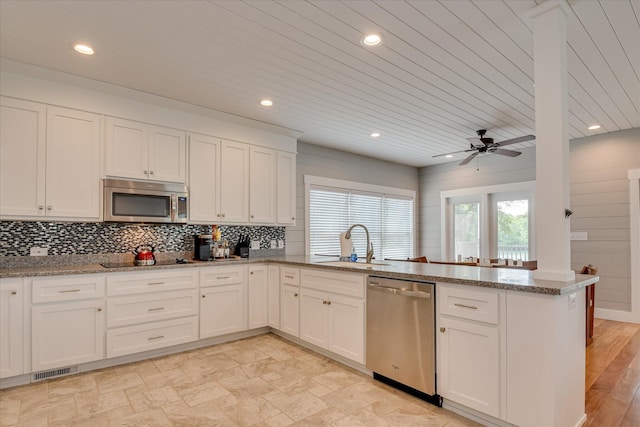 kitchen with visible vents, a sink, a peninsula, stainless steel appliances, and recessed lighting