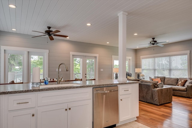kitchen featuring stainless steel dishwasher, open floor plan, ceiling fan, and a sink