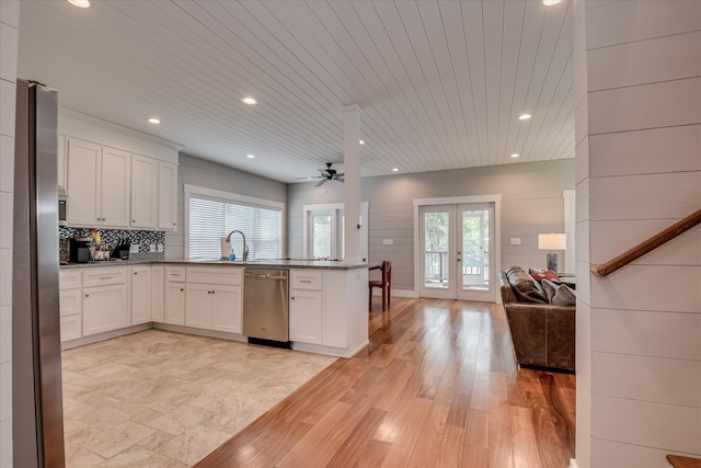 kitchen with a peninsula, open floor plan, white cabinetry, french doors, and stainless steel appliances