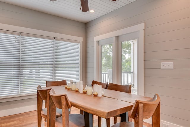 dining space featuring wooden walls, ceiling fan, light wood finished floors, recessed lighting, and baseboards