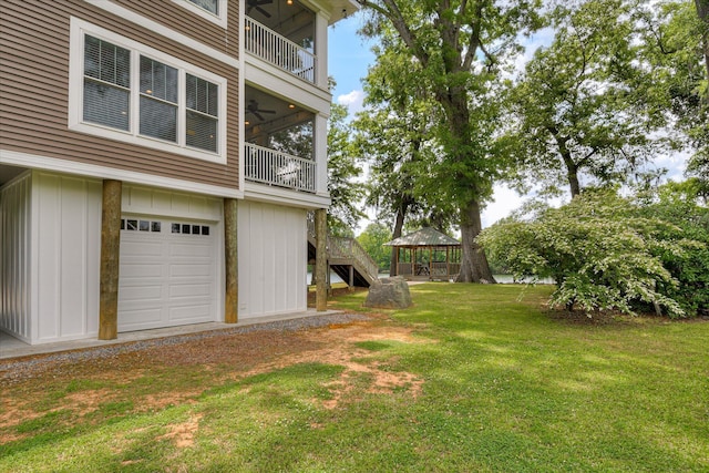 view of yard with a gazebo, a balcony, and a garage