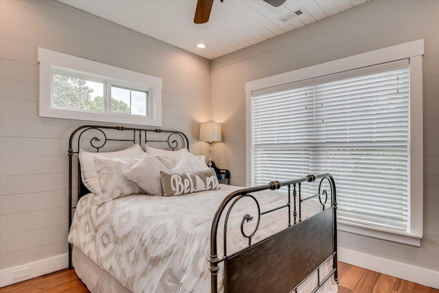 bedroom featuring light wood-style floors, baseboards, a ceiling fan, and visible vents