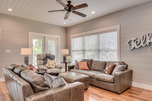 living room featuring recessed lighting, wood walls, and light wood-type flooring