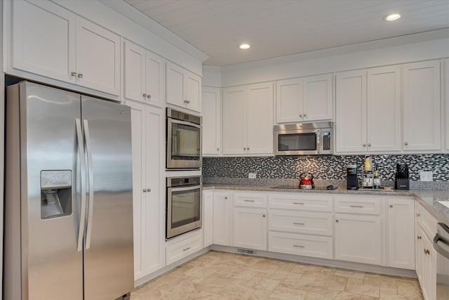 kitchen featuring backsplash, appliances with stainless steel finishes, light stone countertops, recessed lighting, and white cabinetry