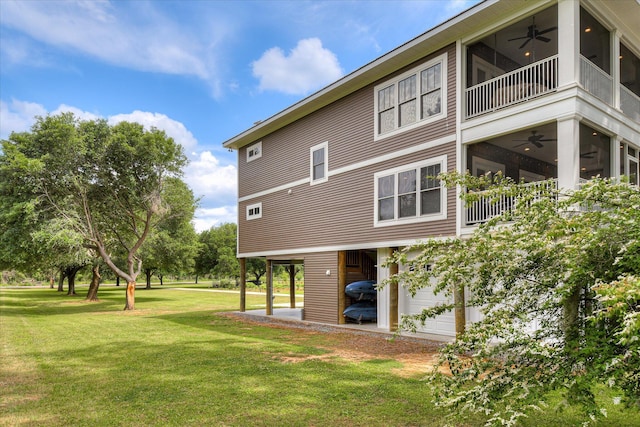 back of house featuring a ceiling fan, a yard, and a balcony